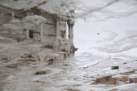 Statua del duomo riflessa in una pozzanghera